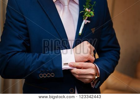 Hands of wedding groom in a white shirt dress cufflinks.
** Note: Shallow depth of field