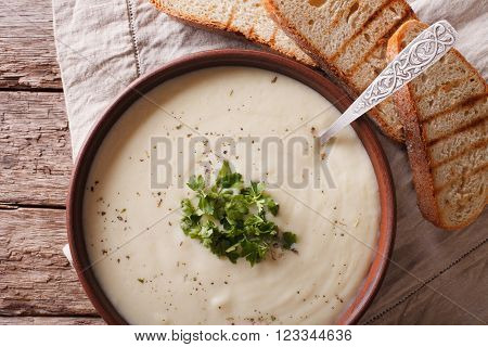 White vegetable cream soup close up in a bowl. horizontal top view