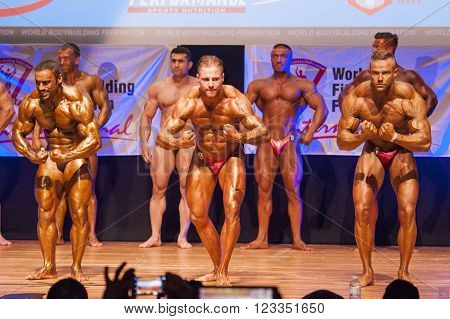 MAASTRICHT THE NETHERLANDS - OCTOBER 25 2015: Male bodybuilders flex their muscles and shows their best most muscular pose on stage at the World Grandprix Bodybuilding and Fitness of the WBBF-WFF on October 25 2015 at the MECC Theatre in Maastricht