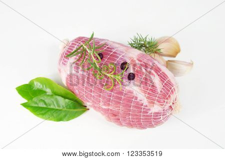 raw ham with rosemary and laurel on plate