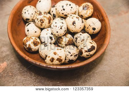 quail eggs are in the brown ware on the brown table