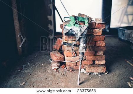 Construction tool, industrial jackhammer with demolition debris and bricks