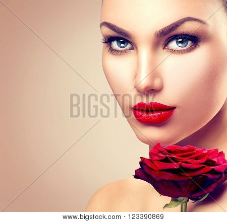 Beauty Fashion Model Woman face. Beautiful Girl Portrait with Red Rose flower. Red Lips. Beautiful Woman with Luxury Makeup. Skin care concept. Fresh Clean Skin. Beige background