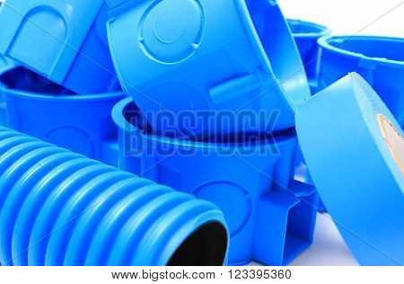 Heap of blue electrical boxes and components for use in electrical installations, accessories for engineering jobs