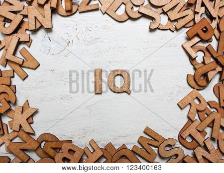 Word IQ (intelligence quotient) are made with wooden letters on an old white wooden background