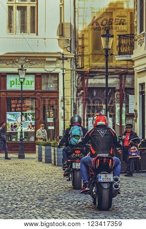 Bucharest Romania - October 6 2013: Motorcyclists ride powerful sport motorcycles on the cobblestone streets of the historic center Lipscani the Bucharest's the most attractive area for tourists.