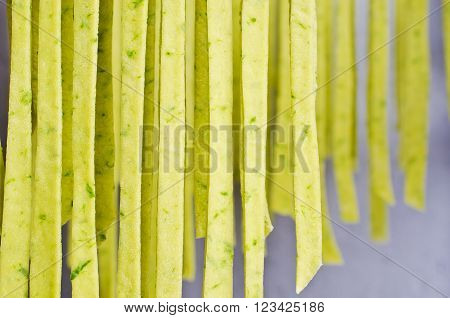 Homemade tagliatelle green hanging to dry. Selective focus.