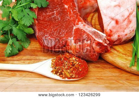 raw meat : fresh beef pork big rib and fillet with garlic and green stuff on wood isolated over white background