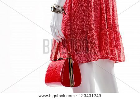 Dress and purse on mannequin. Female mannequin in red clothes. Dotted dress with red bag. Lady's fashionable pieces of clothing.