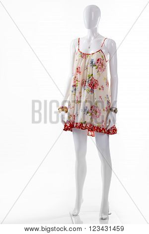 Sarafan and bracelet on mannequin. Female mannequin wearing light clothes. Classic watch and floral sarafan. Seasonal sale of women's clothing.