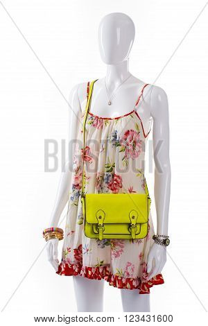 Bag and sarafan on mannequin. Female mannequin wearing lime bag. Lime bag and floral sarafan. Woman's classy light-colored purse.