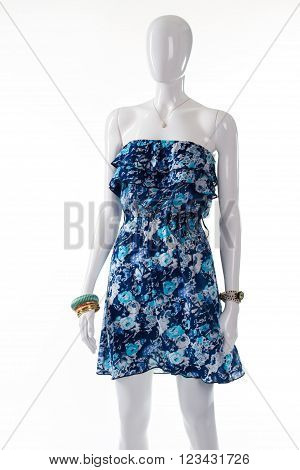 Blue summer dress on mannequin. Female mannequin wearing thin dress. Blue garment with small pendant. Lady's precious accessory and dress.
