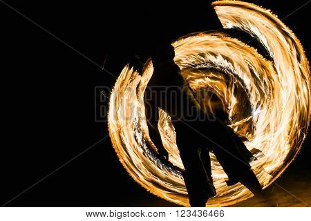 a man showing fire dancing flaming trails.