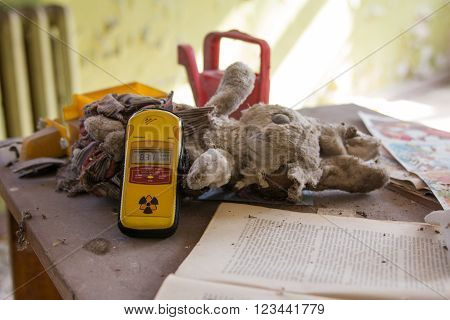 UKRAINE, PRYPIAT - MARCH 19, 2016: Dosimeter on old  toys in the abandoned kindergarten
