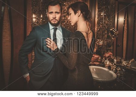 Well-dressed couple in luxury bathroom interior.