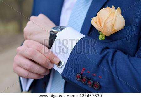 masculine hands hold a cuff-link suit suit wedding fiance