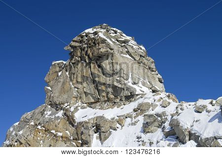 A rock in the shape of the head of a human or a fairy creature. The top of the Hintertux glacier in the Austrian Alps. Height - 3250 meters above sea level.