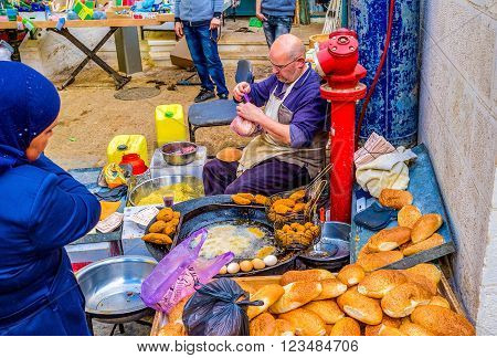 BETHLEHEM, PALESTINE - FEBRUARY 18, 2016: The outdoor cook prepares the falafel on frying pan in the Bethlehem market on February 18 in Bethlehem.