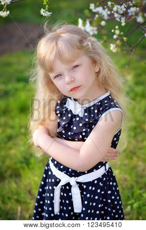 a girl in a dress sits on fresh air spring