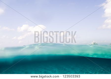 A yatch on the sea surface with the sky and the sea bottom in the Mediterranean Sea
