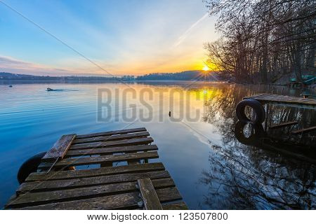 Sunrise over lake at end of winter. Frosty morning with sunrise over lake.