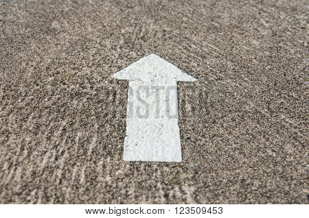 White arrow sign on a road surface