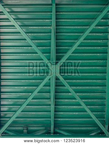 green, metal, bottom of bridge, large X