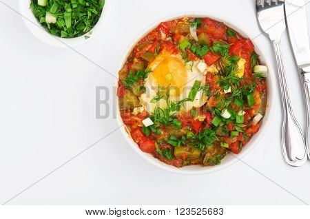 Shakshuka with egg in white bowl on a white background top view with copy space. Healthy food.
