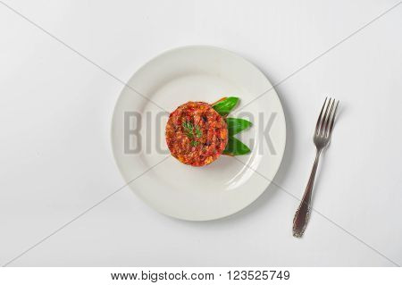 Vegetable stew in a white plate on a white background top view. Healthy food