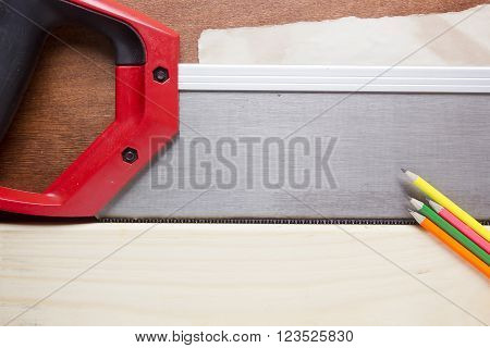 Toothed steel hand saw cutting through a new boards of wood left in position surrounded by wood chips with nobody in the frame in a DIY carpentry woodworking or joinery concept