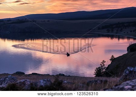 Dramatic red sunset over baikal lake with a sailboat and a redsky