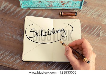 Retro effect and toned image of woman hand writing a note on a notebook. Handwritten text in German 