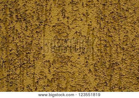 Dark yellow wall covered with rough plaster