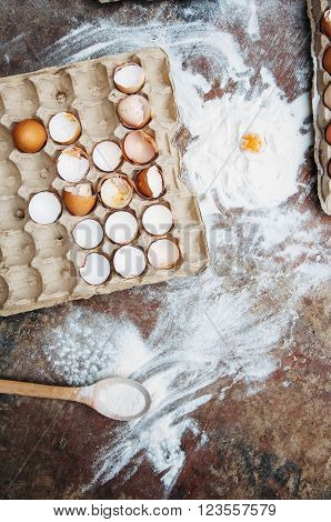 Baking cake ingredients - bowl flour eggs egg whites foam eggbeate on wood chalkboard from above. Cooking course or kitchen mess poster concept. Flat lay. Rustic style