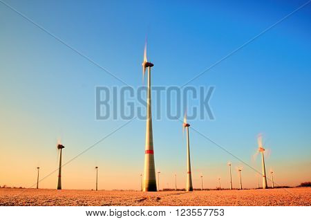 Wind Turbines Producing Electric Energy within sunny spring morning. Vintage Style Toned effect