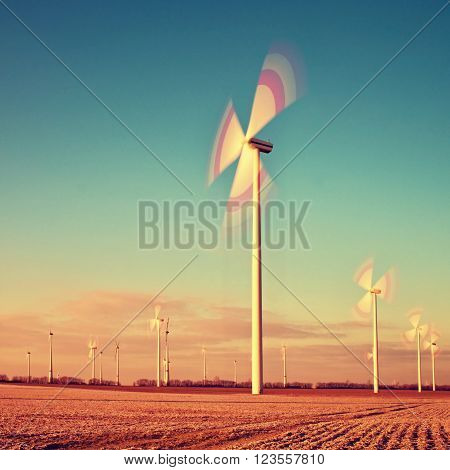 Wind Turbines Producing Electric Energy within sunny spring morning. Vintage Style Toned effect