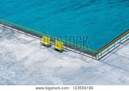 Two Yellow Benches on a Conrete Pier