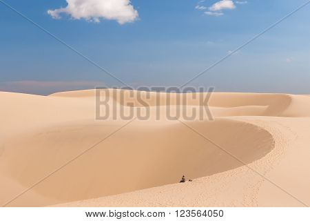 Alone man in desert. The White Dunes (bau sen bau trang)- landmark near Mui Ne Binh Thuan Vietnam.