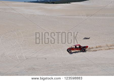 LANCELIN,WA,AUSTRALIA-SEPTEMBER 28,2015: Red dune buggy with checkered flag on the white sand dunes recreational attraction in Lancelin, Western Australia.