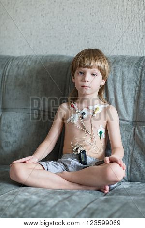Child sitting on the sofa. Heart cardiogram or monitoring of cardiac performance using Holter.
** Note: Visible grain at 100%, best at smaller sizes