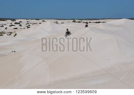 LANCELIN,WA,AUSTRALIA-SEPTEMBER 28,2015: Motorbike recreational vehicles racing the peaks of the white sand dunes in Lancelin, Western Australia.