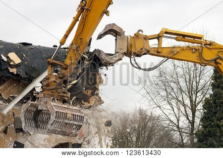 Two yellow demolition cranes dismantling a building