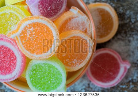Jelly sweet flavor fruit candy dessert colorful in ceramic bowl on wood background.