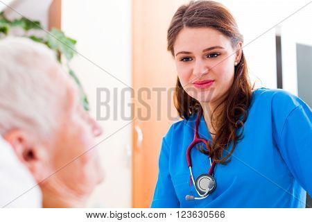 Kind Nurse Listening To Senior Sick Woman