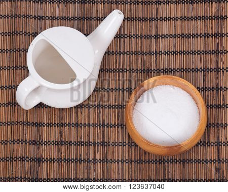 Ceramic neti pot and sea salt in bowl