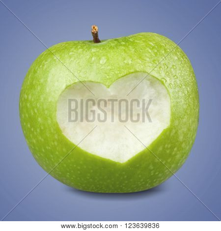 Green apple with a heart shaped cut-out on backgrouund