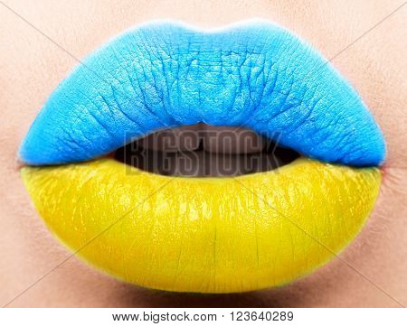 Female lips close up with a picture of the flag of Ukraine. Blue, Yellow