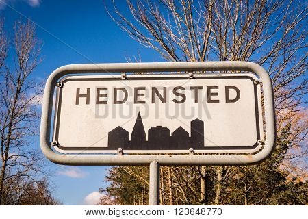 Hedensted city sign in Denmark with trees in the background