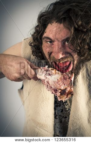 Silly hungry cave man eating ham on the bone