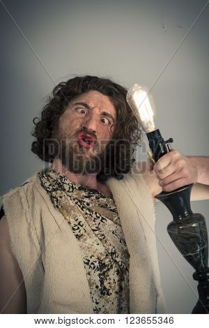 Silly realistic caveman dumbfounded by confusing lightbulb